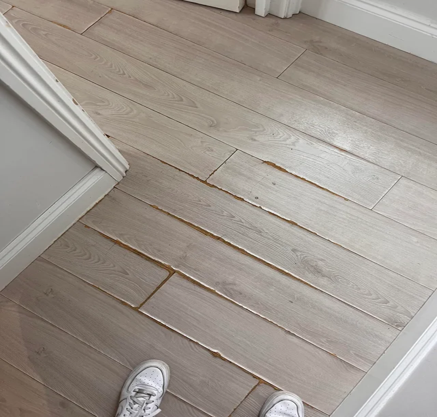 person standing on ruined hardwood floor